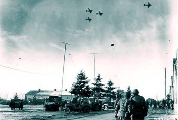 Saveznički avioni izbacuju preko potrebne namirnice, medicinski materijal i municiju opkoljenim padobrancima kod Bastonja