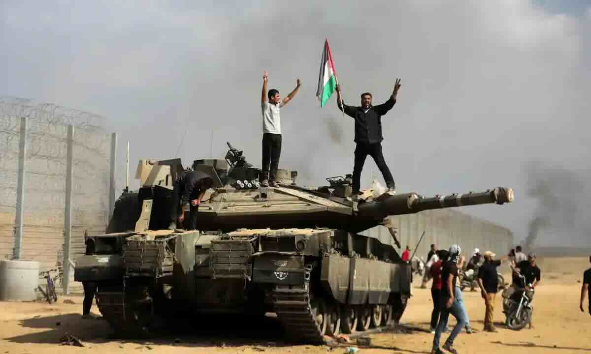 palestinci masu nacionalnom zastavom na vrhu izraelskog tenka merkava istocno od granicnog prelaza kan junis